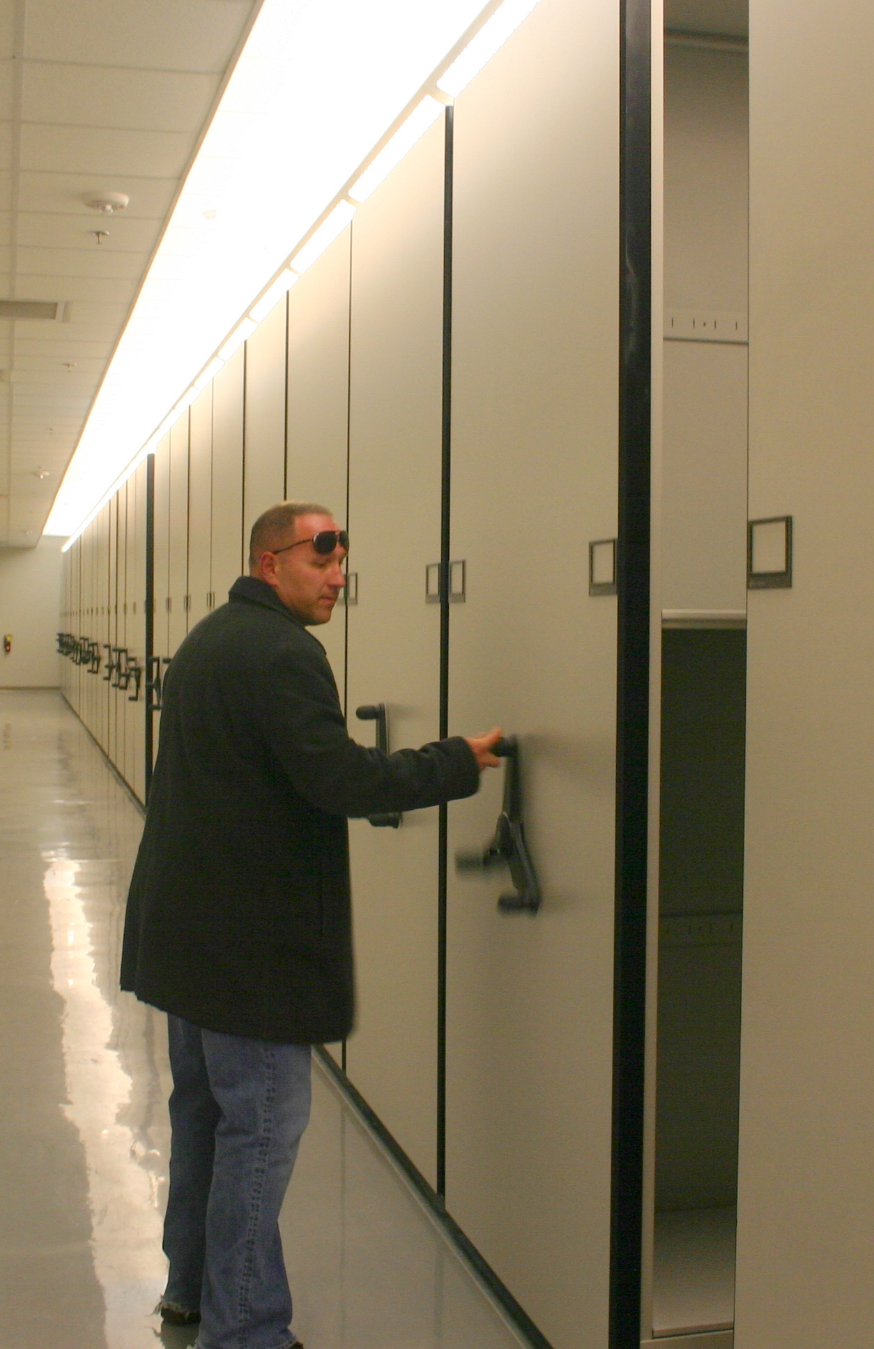 Lt. Robert Gavin demonstrates using the space-saving mobile shelves where boxes of evidence will be stored. 