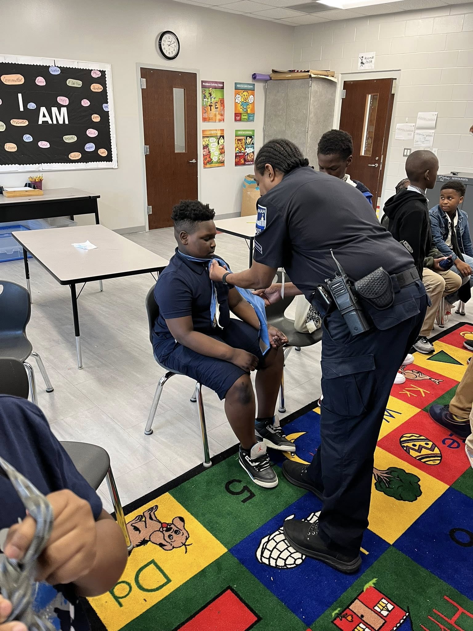 SIP Young Men Stand at Juliette Low Elementary Learning how to tie neckties